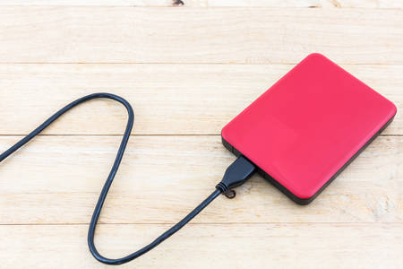 External hard drive for backup on wood background.の写真素材