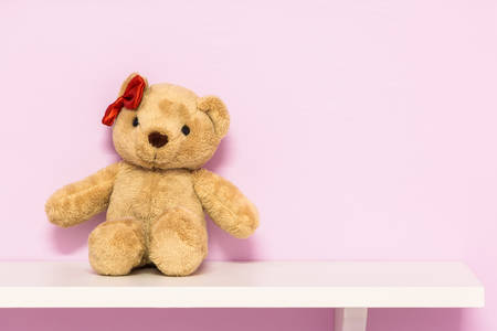 Classic teddy bear on shelf. Brown teddy on the pink background.の写真素材