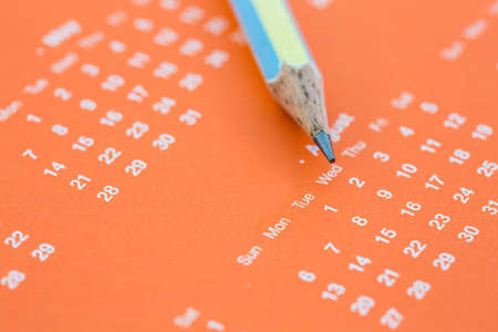 Closeup of calendar page and pencil to mark save the date.の写真素材