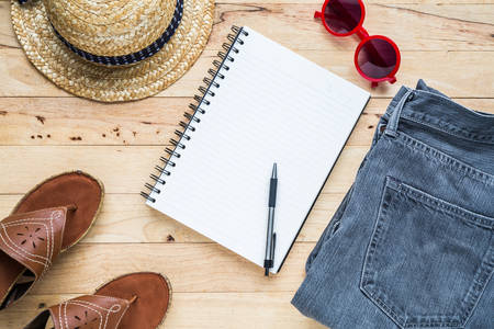 Flat lay fashion set: Notebook and copy space, jean ,sunglasses, hat. Top view.の写真素材