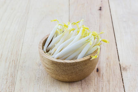 Bean sprout in the wood bowl on wood background.の写真素材