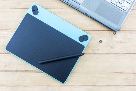 Digital graphic tablet and pen on wood desk Background.の写真素材