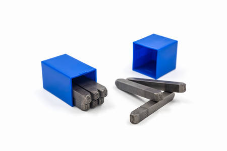 The metal lettering stamps punch set in a plastic box on the white background.の写真素材