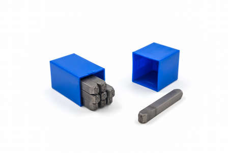 The metal lettering stamps punch set in a plastic box on the white background.の写真素材