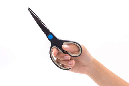 Closeup hand holding black steel scissors on white background.の写真素材