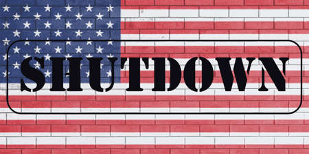 With the word Shutdown on flag of united states of america painted over on brick wall.