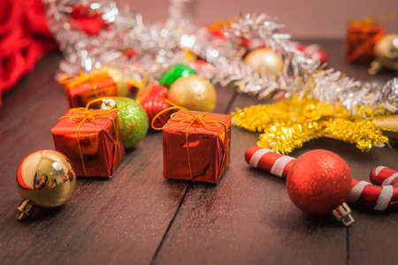 selective focus Christmas background with a red ornament, golden gift box, berries on black wood blackground still lifeの写真素材