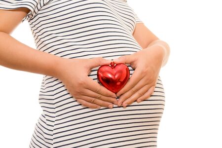 Pregnant woman belly holding gift heart. isolated on white