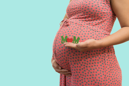Label "Baby" in the hands of a pregnant woman on blue background soft colorの写真素材
