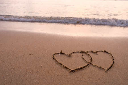 two hearts drawn in beachの写真素材