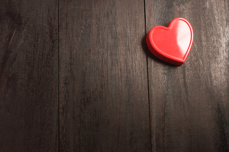 red heart pendant on a background of wood. Valentine's Day. Valentine day. Heart pendant. Red heart. Space for text. Eighth of March. International Women's Day.の写真素材