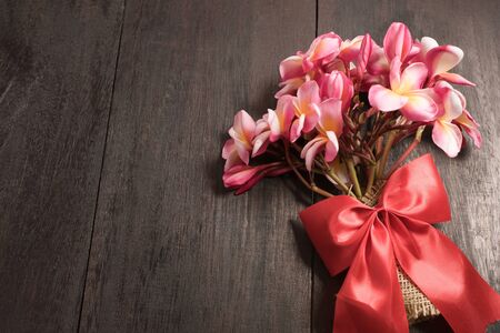 The beautiful pink Plumeria flower on the old wood background still lifeの写真素材