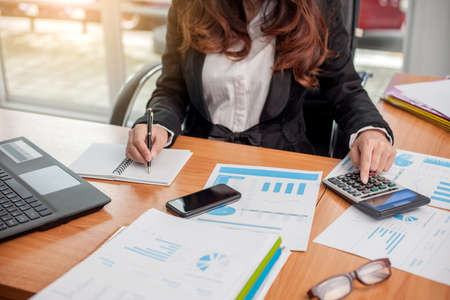 Business woman at working with financial reports and laptop computer in the office