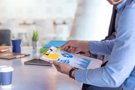 Businessman meeting together using graphs at the office.