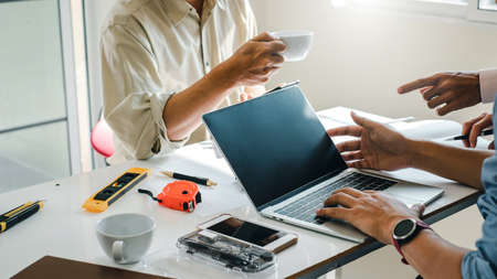 Team architect man in the office talking and drawing blueprint about the construction project.の写真素材