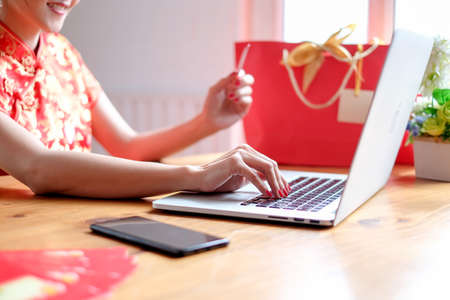 Happy chinese new year. Chinese woman in traditional clothing and shopping online.の写真素材