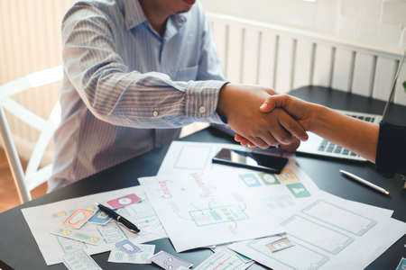 Mobile application designers shaking hands and plan together in the office.の写真素材