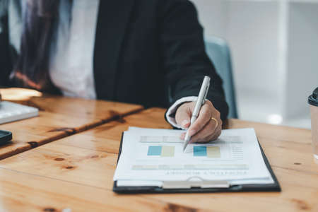 Close-up of a businesswoman pointing to a graph at the office.