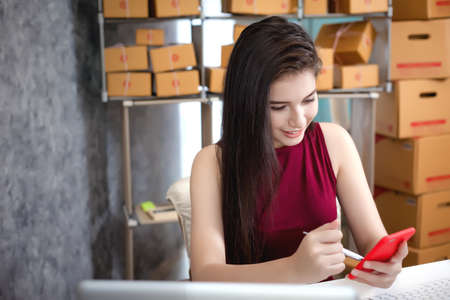 Young woman using smart phone laptop and computer. Entrepreneurs success in doing business. Shipment Online Sales.の写真素材
