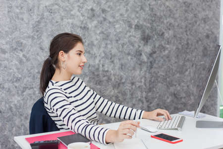 Beautiful Young woman working on laptop and computer in the officeの写真素材