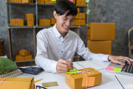 Entrepreneur young man note taking customers information. Shipping and Deliveryの写真素材