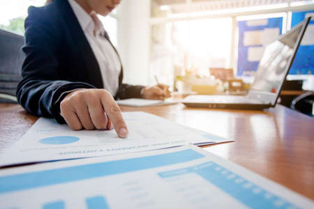 Business woman at working with financial reports and laptop computer in the officeの写真素材