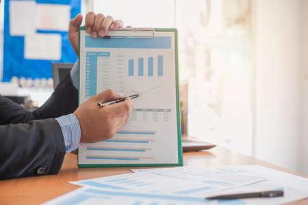 Business woman at working with financial reports and laptop computer in the office