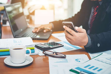 business man working using smart phone and notebook computer in the officeの写真素材
