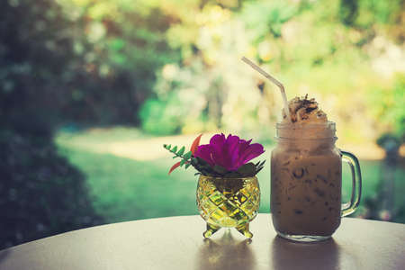 Iced coffee and flower  vase on the table style vintage.の写真素材