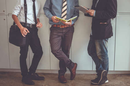 Businessman standing talking. Business people using a digital tabletの写真素材