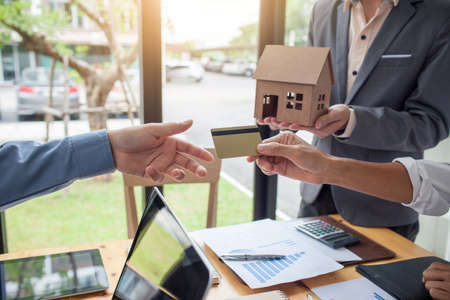 Hands of men who are submitting credit cards to customers, the concept of home loan with credit.の写真素材