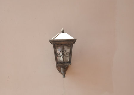 Vintage street lamp on the wall of a building in the cityの写真素材