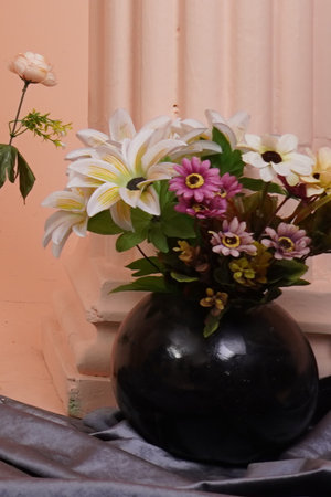 Flowers in a vase on the background of a pink wallの写真素材