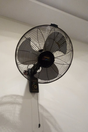 electric fan on a white wall in a room, closeup of photoの写真素材