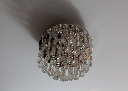crystal chandelier hanging on the ceiling, closeup of photoの写真素材