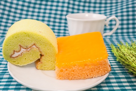 orange cake and jamroll cake on deckの写真素材