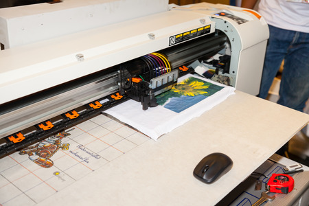 BANGKOK - JUNE 28 :Unidentified worker show digital t-shirt printer work with Sewing 
machine at Garment Manufacturers Sourcing 2014 2014 on June 28,2014 in BITEC ,Bangkok, 
Thailand.のeditorial素材