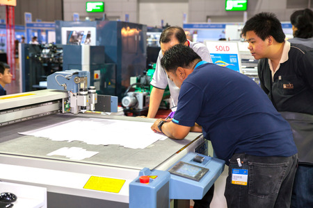 BANGKOK - SEPTEMBER 27 :Unidentified people check with CNC paper cutting at GASMA PRINT 2014 on Sep 27,2014 in BITEC ,Bangkok, Thailand.のeditorial素材