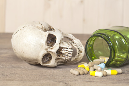 human skull with drugs on woodの写真素材
