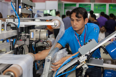 BANGKOK ,THAILAND - JULY 11: Unidentified people put a plastic roll into machine at InterPlas...