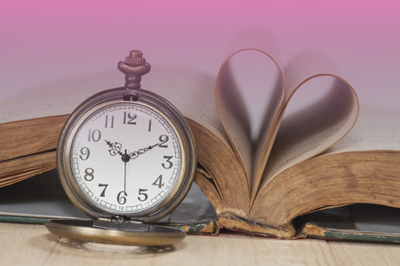 Old books and pocket watches on wooden desk.still life tone