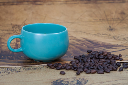 cup of coffee and bean lies on an ancient mapの写真素材