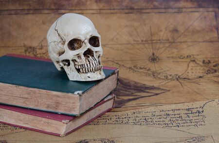 Human Skull and old text book on Old map Backgroundの写真素材