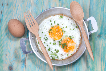 Egg in pan on wood tableの写真素材