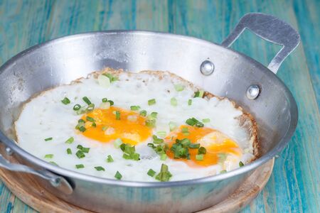 Egg in pan on wood tableの写真素材