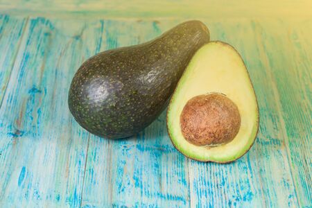 ripe avocado cut in half on a wooden table