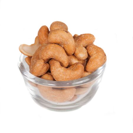 Glass bowl full with cashew nuts. Isolated on a
white background. Glass bowl full with cashew nuts. Isolated on a
white background.