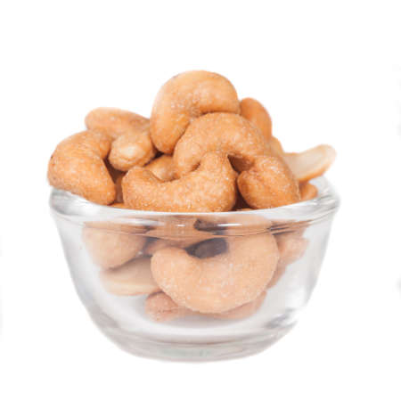 Glass bowl full with cashew nuts. Isolated on a
white background. Glass bowl full with cashew nuts. Isolated on a
white background.