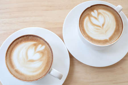 Hot art Latte Coffee in a cup on wooden tableの写真素材