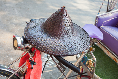 Traditional hat made of bamboo wood and dry 
leaves on vintage bicycleの写真素材